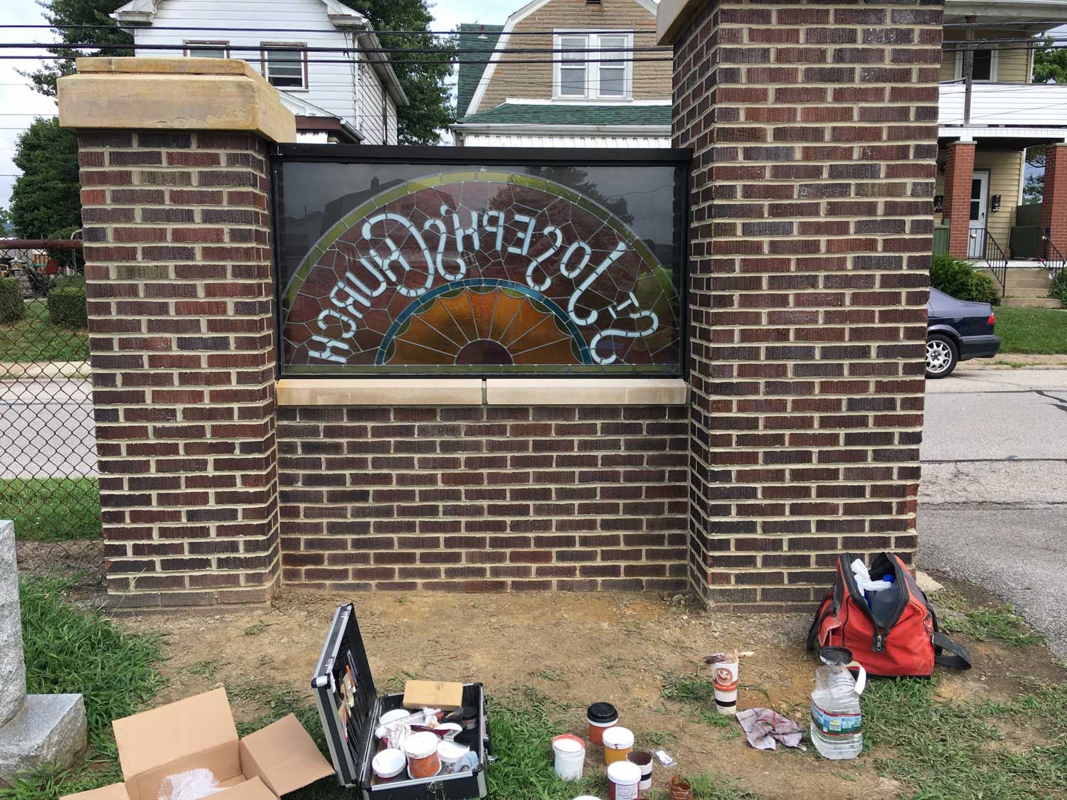 A brick wall with a stained glass window on it