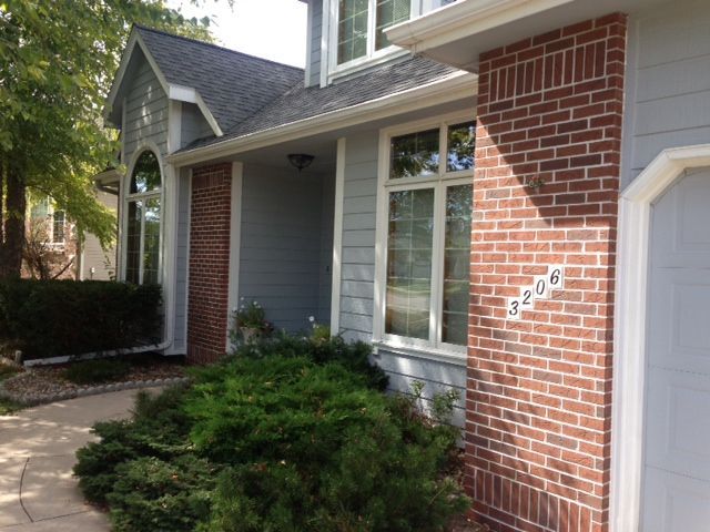 A house with a brick facade and a white siding