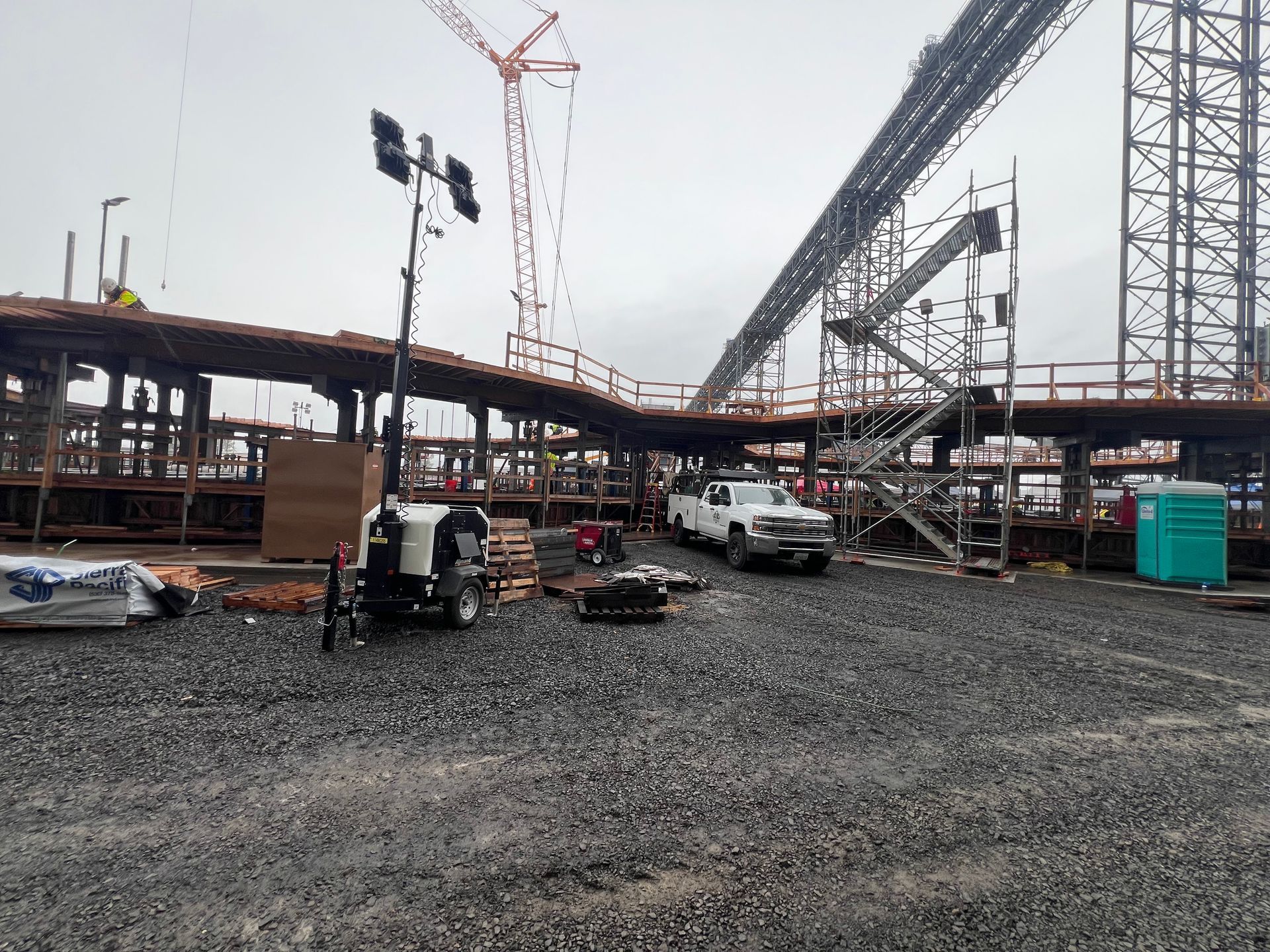 A construction site with a lot of trucks parked in the dirt.