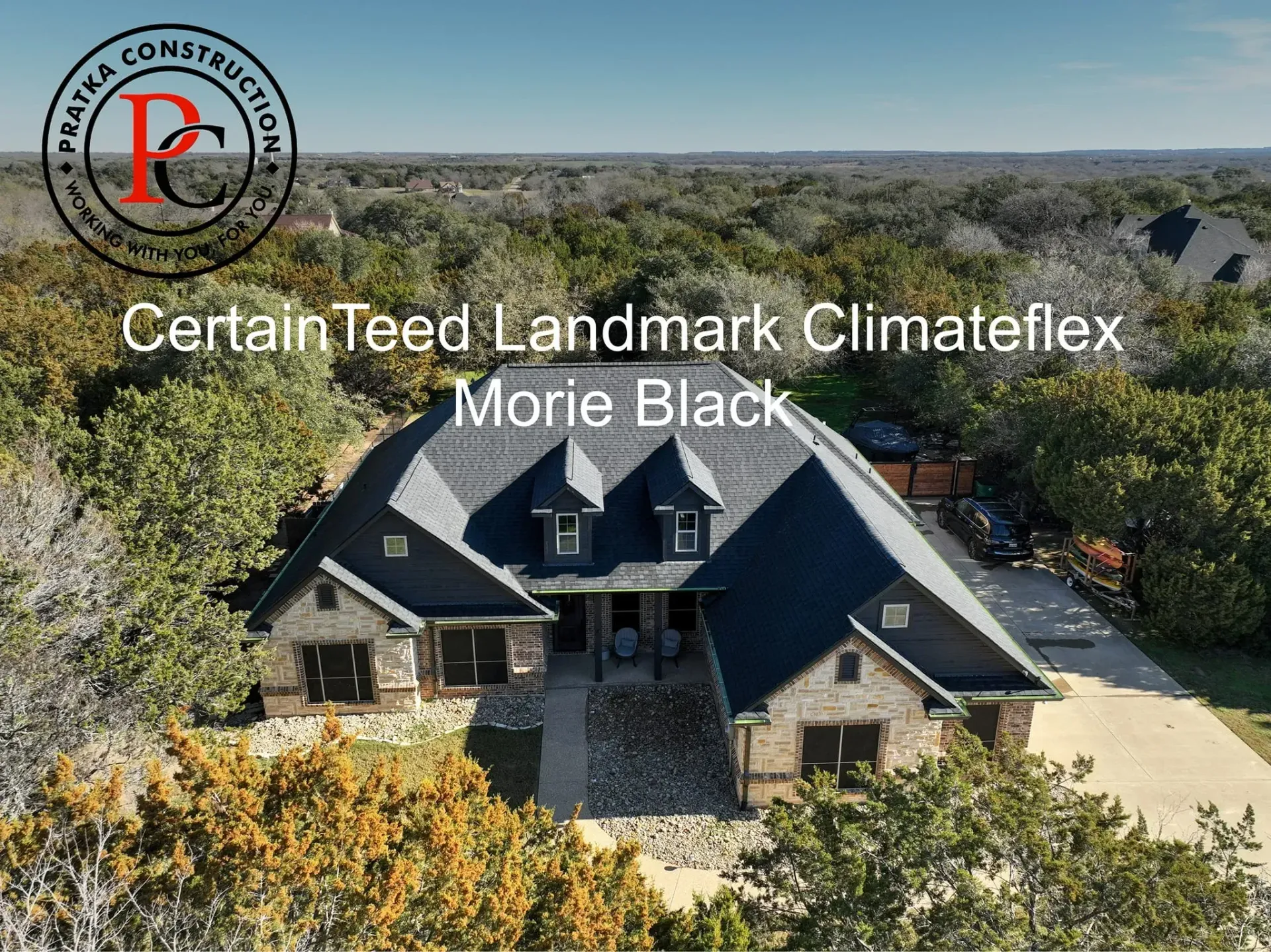 House with black roof (CertainTeed Landmark Climateflex Morie Black). Surrounded by trees.