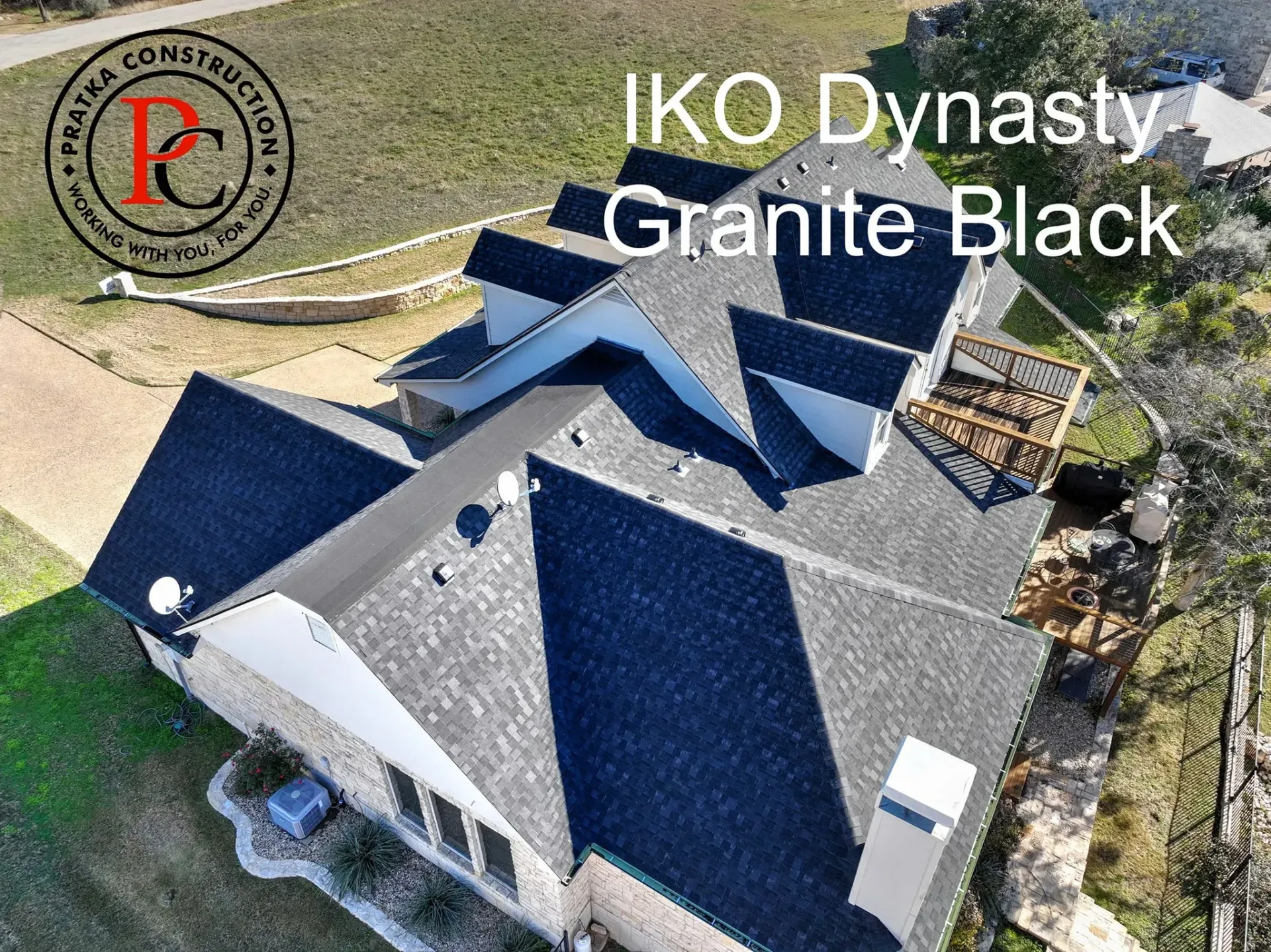 Overhead view of a house with a black roof, labeled IKO Dynasty Granite Black, with a company logo on the left.