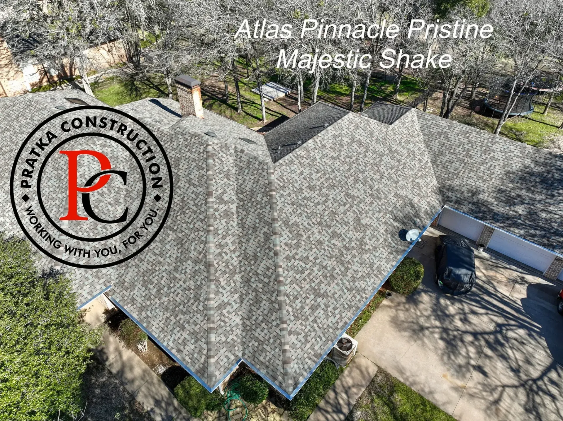 Aerial view of a house with a Majestic Shake roof. The logo of Pratika Construction is in the foreground.