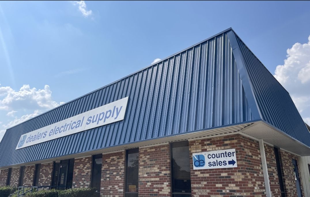 A blue-roofed brick building, "Dennis Electrical Supply," with a "Counter Sales" sign.