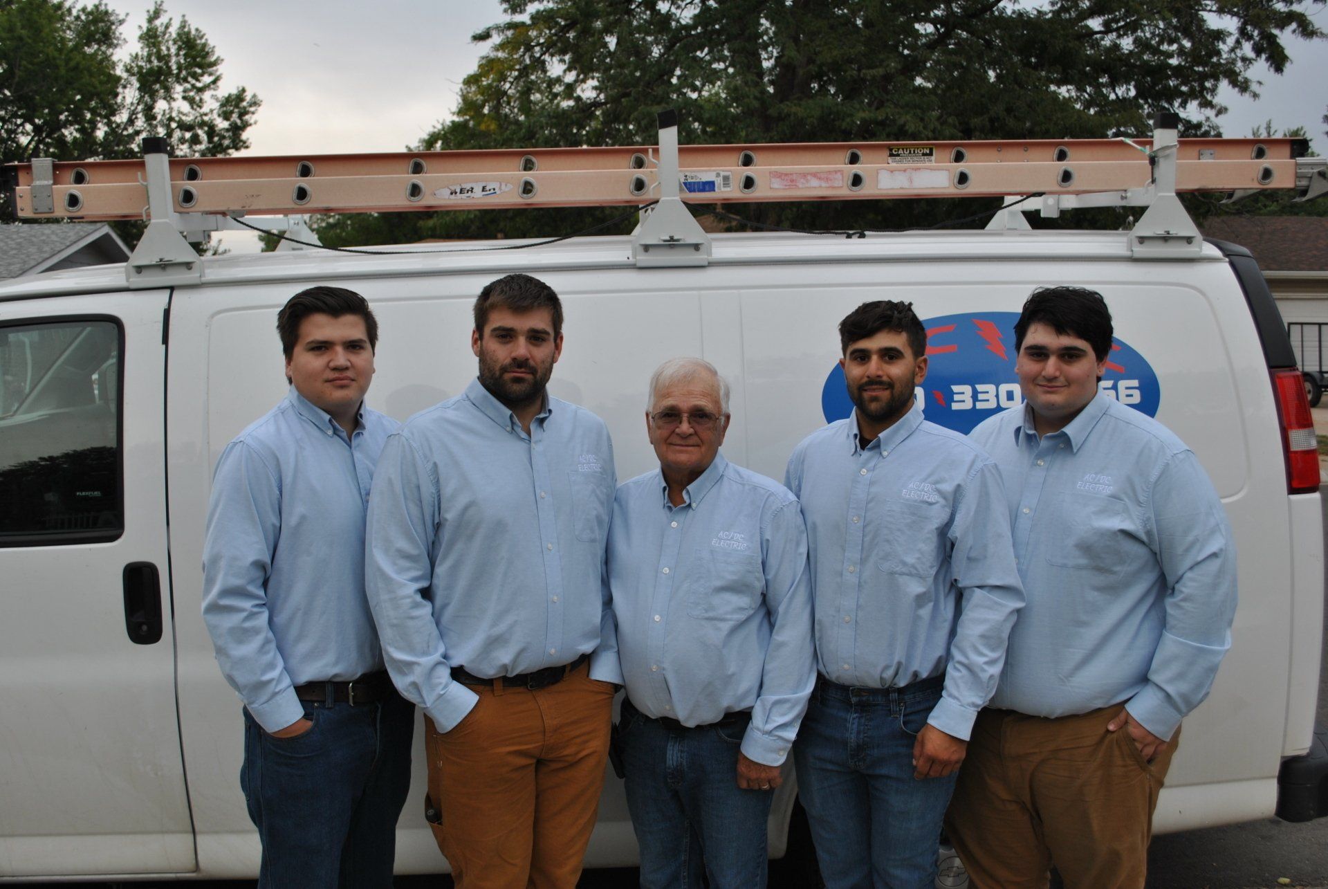 A security camera is sitting on top of a pole in front of a building.