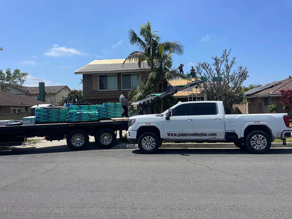 A white truck is parked on the side of the road next to a trailer.