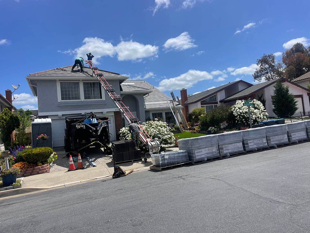 A couple of men are working on the roof of a house.