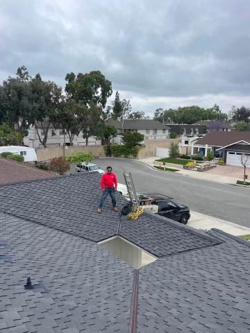 A man is standing on the roof of a house.