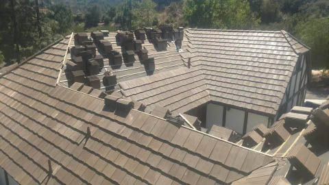 An aerial view of a house with a tiled roof being installed.