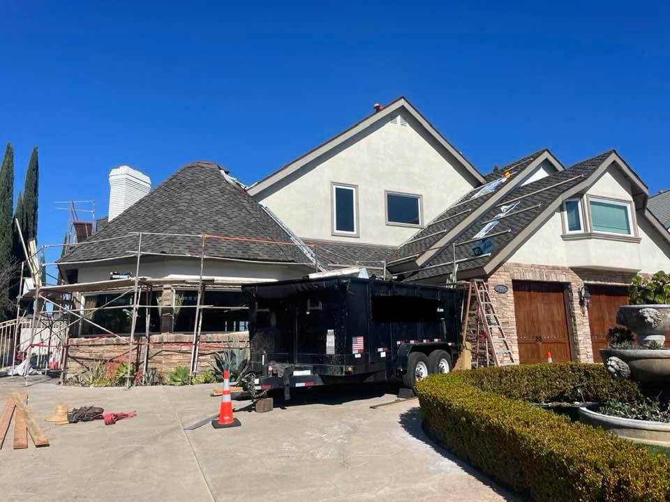 A large white house with a trailer parked in front of it.