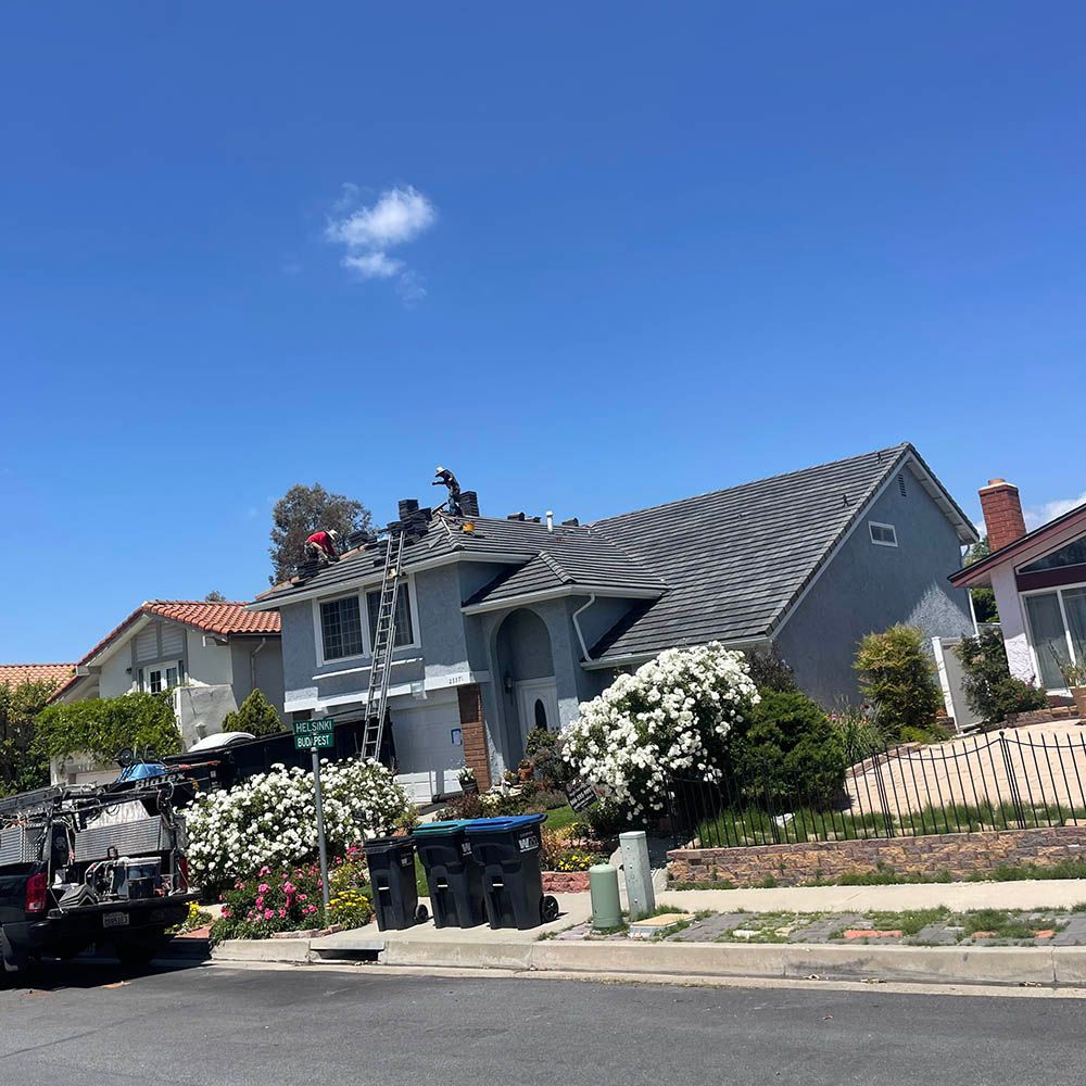 A group of people are working on the roof of a house.