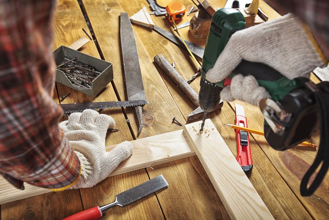 artigiano durante intervento di ristrutturazione di un tavolo in legno
