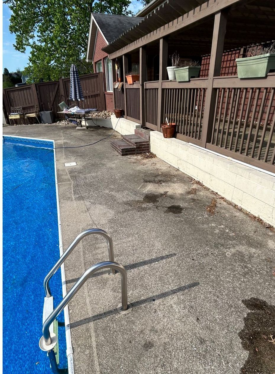 A swimming pool with stairs leading to it and a house in the background