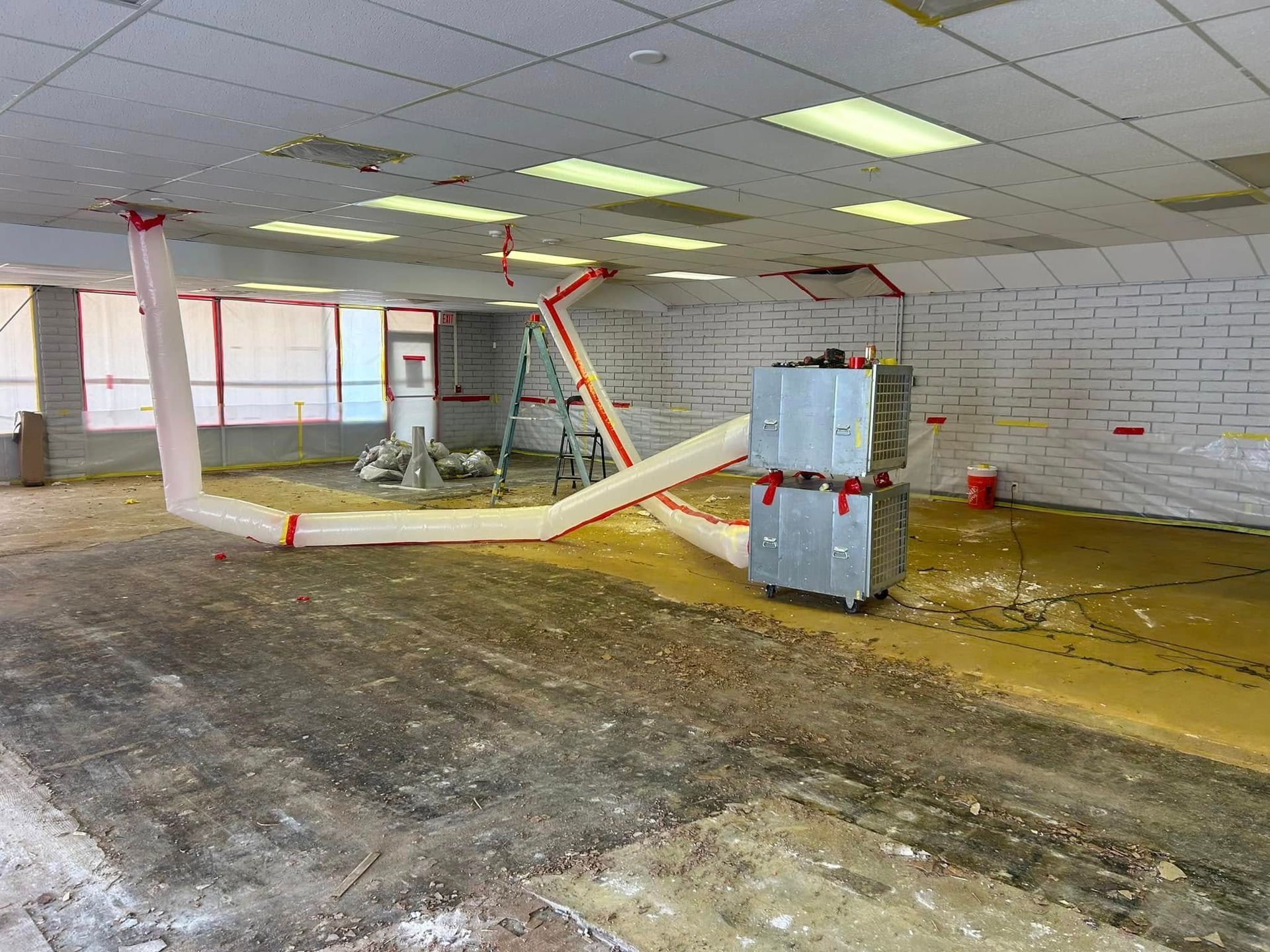 A room with a concrete floor and a vacuum cleaner in it.