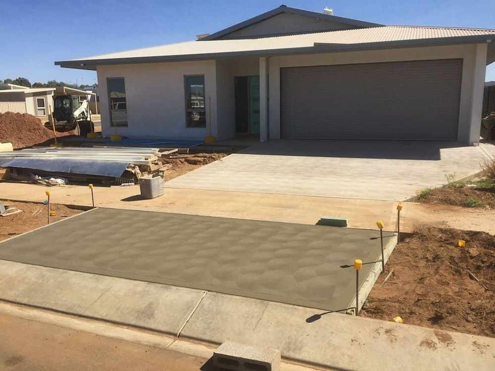 A Concrete Driveway Is Being Built In Front Of A House — Heartland Concrete In Gillen, NT