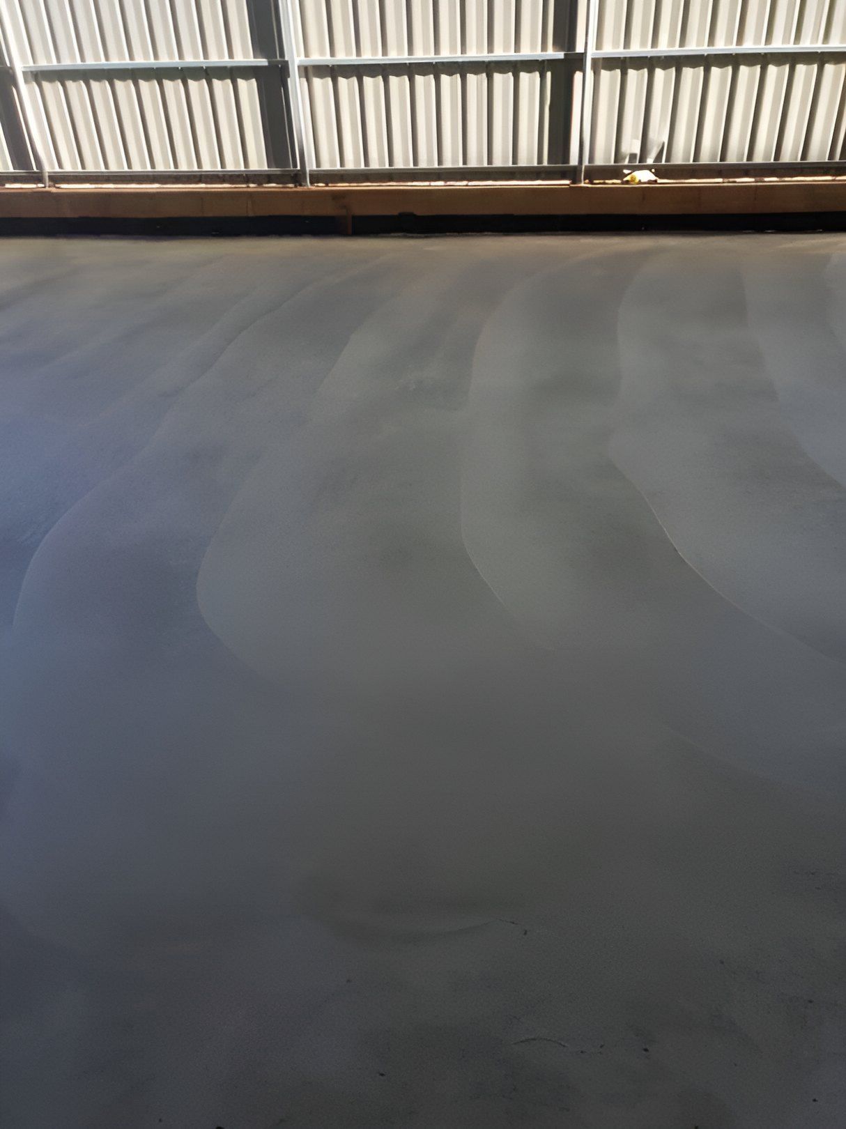 A Gray Concrete Floor With A White Fence In The Background — Heartland Concrete In Gillen, NT