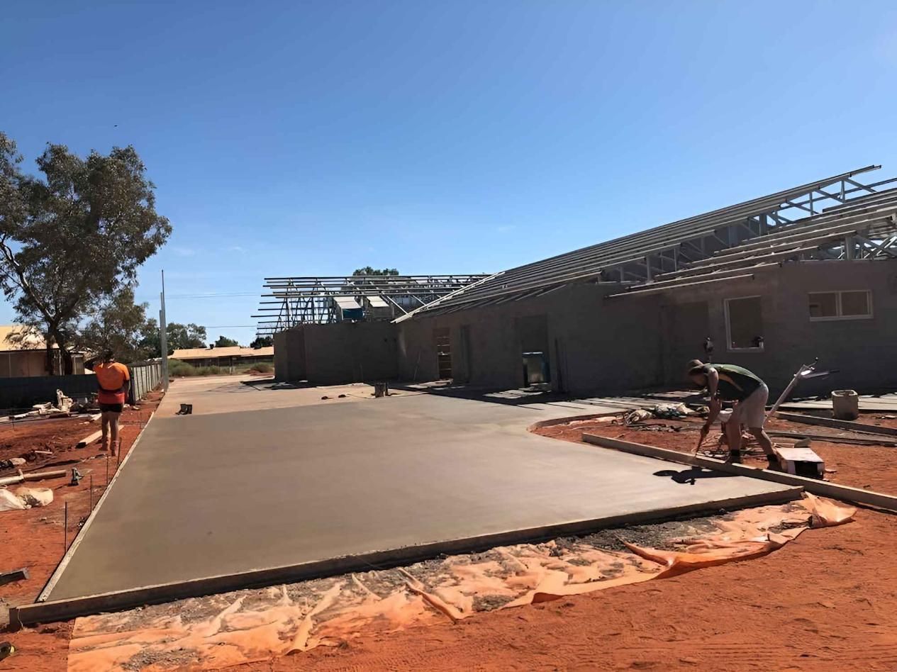 A group of construction workers are working on a concrete driveway — Heartland Concrete In Gillen, NT
