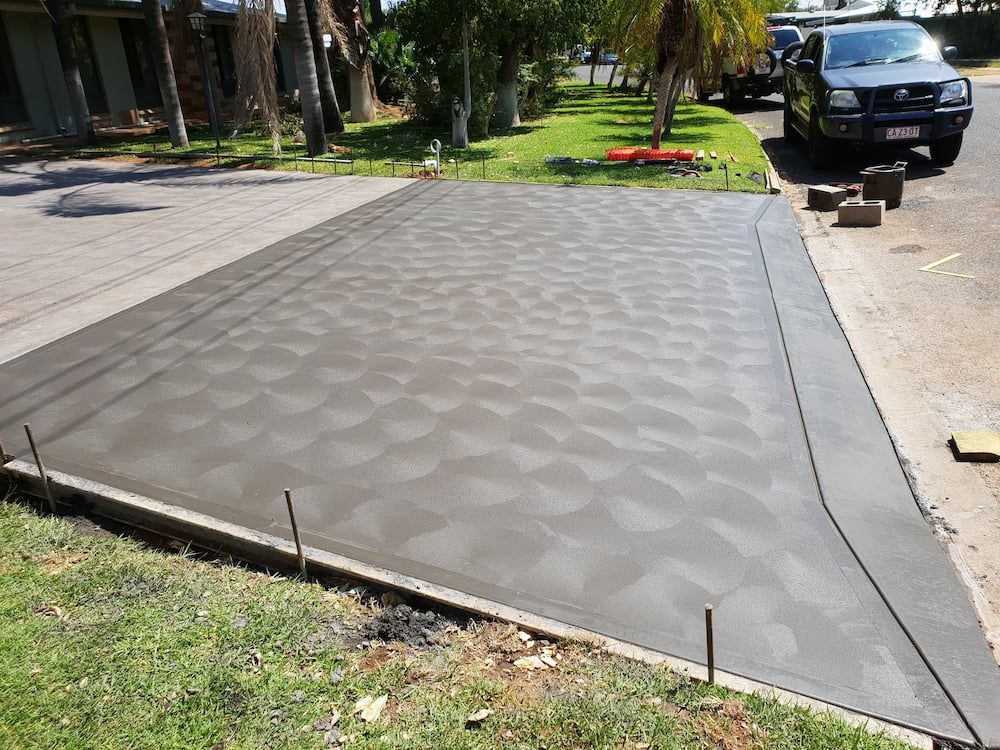 A Car Is Parked On The Side Of A Concrete Driveway — Heartland Concrete In Gillen, NT