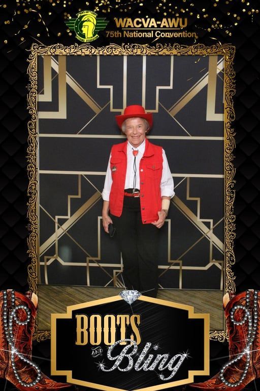 A person wearing a red vest and hat poses for a