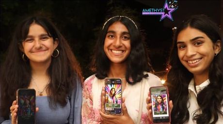 Three people smile while holding up smartphones displaying personalized digital portraits against a dark background.