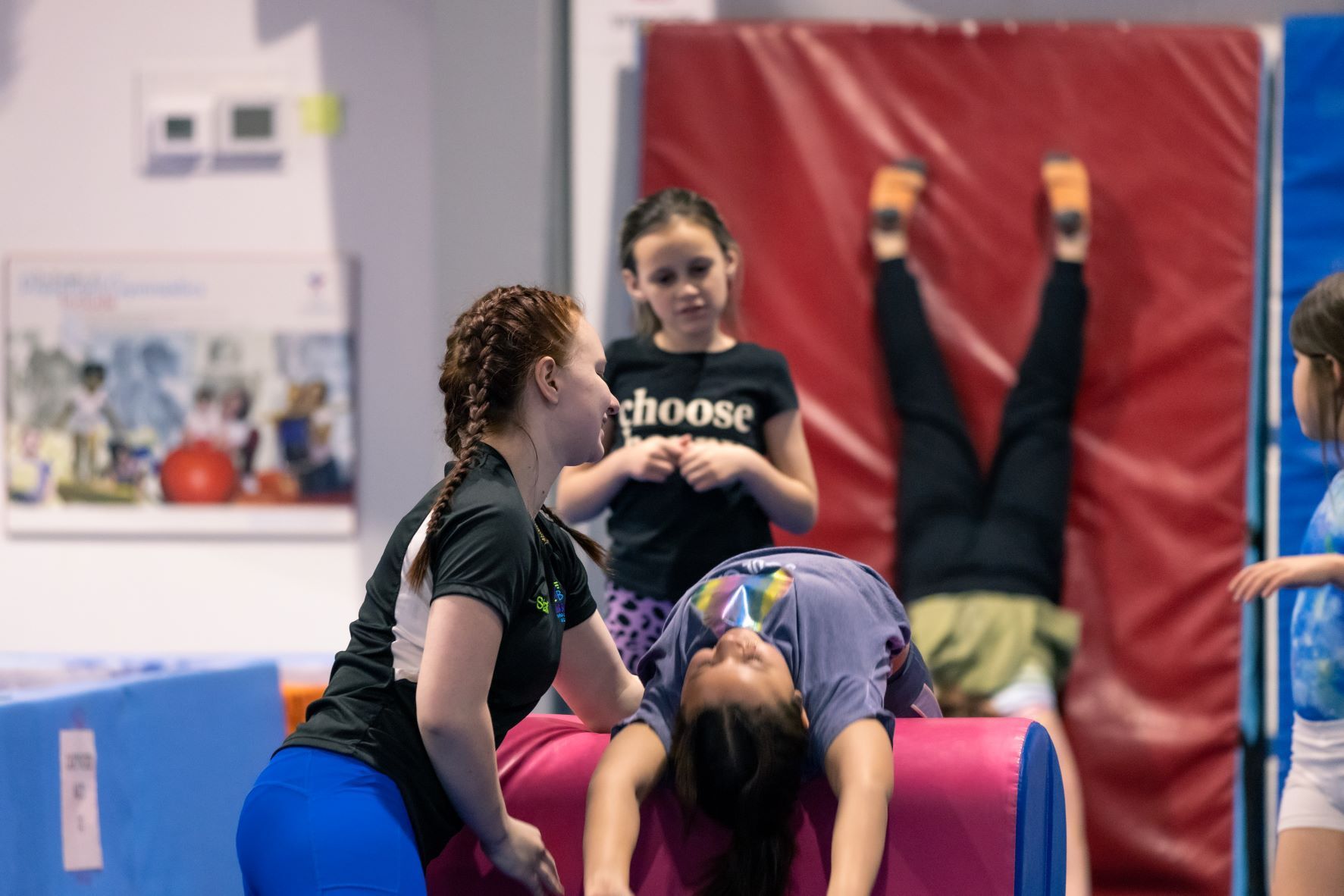 A group of people are doing gymnastics in a gym.