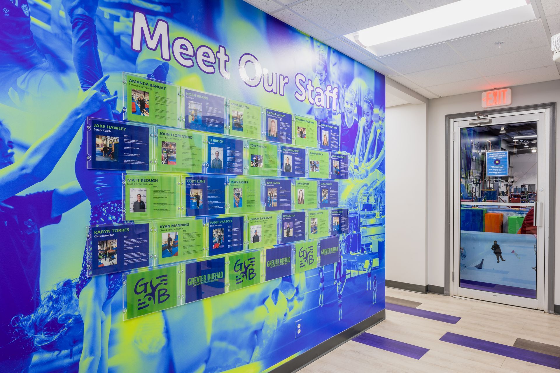 A hallway with a mural on the wall that says `` meet our staff ''.