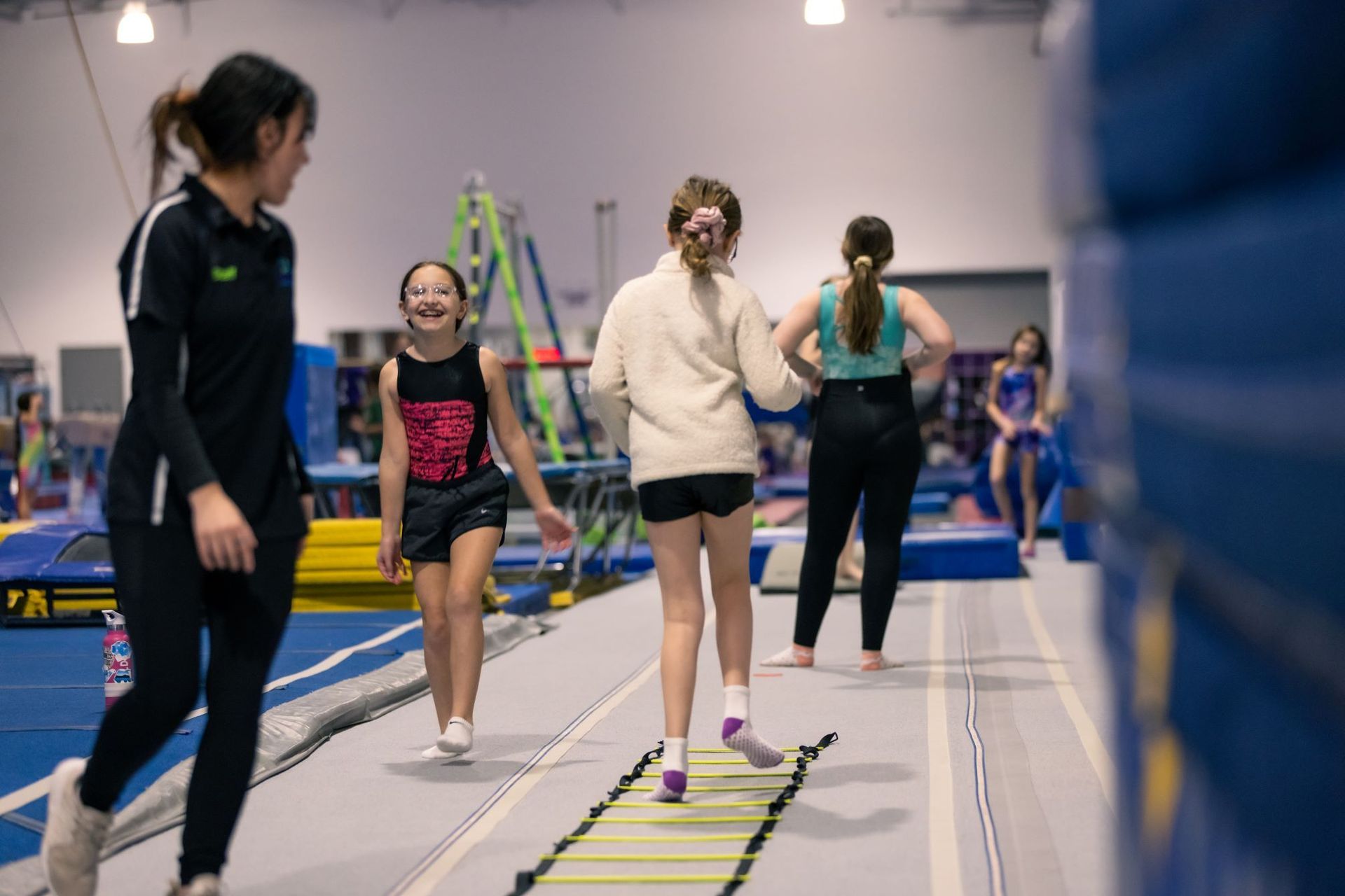 A group of young girls are practicing gymnastics in a gym.