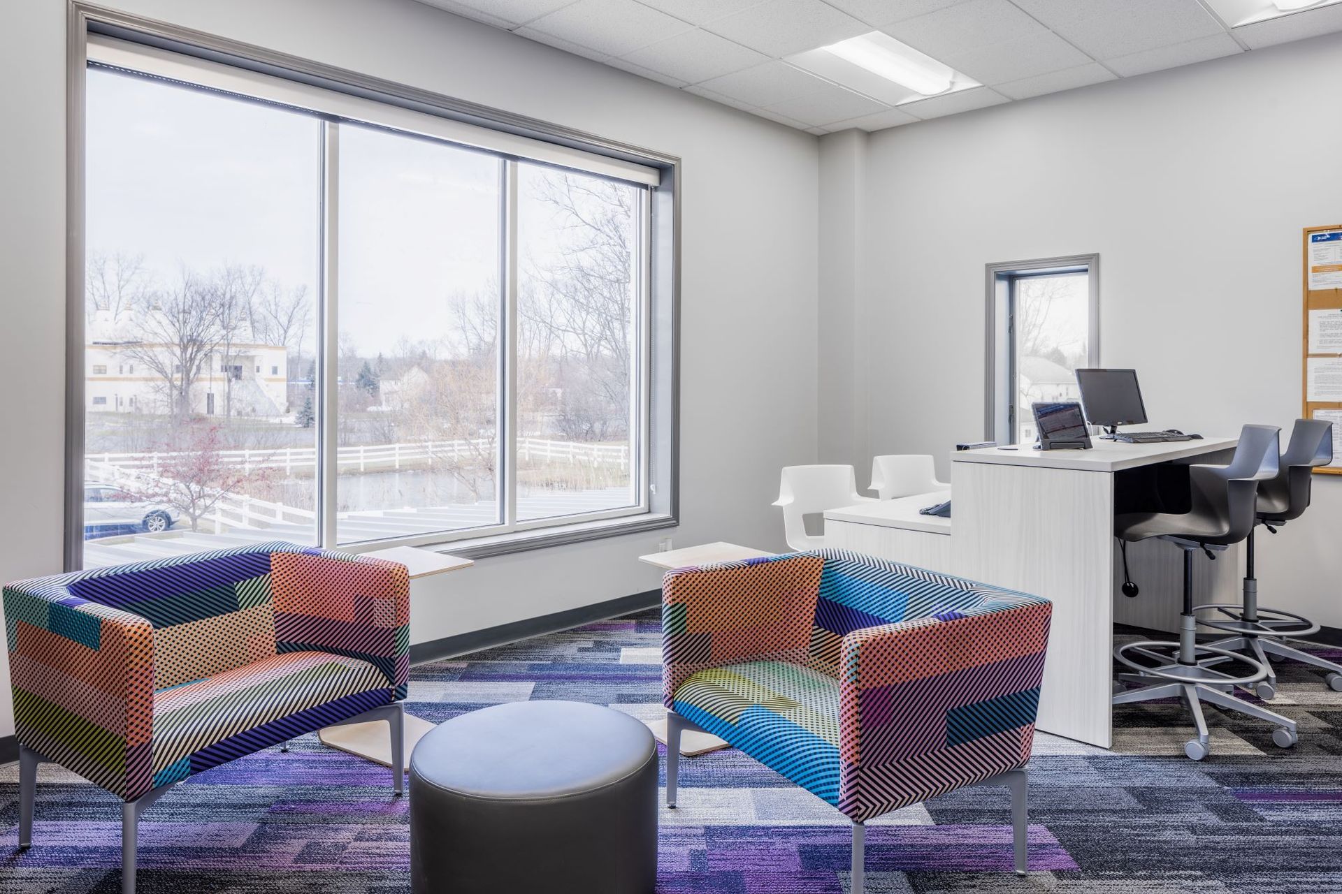 A room with chairs , a table , and a large window.