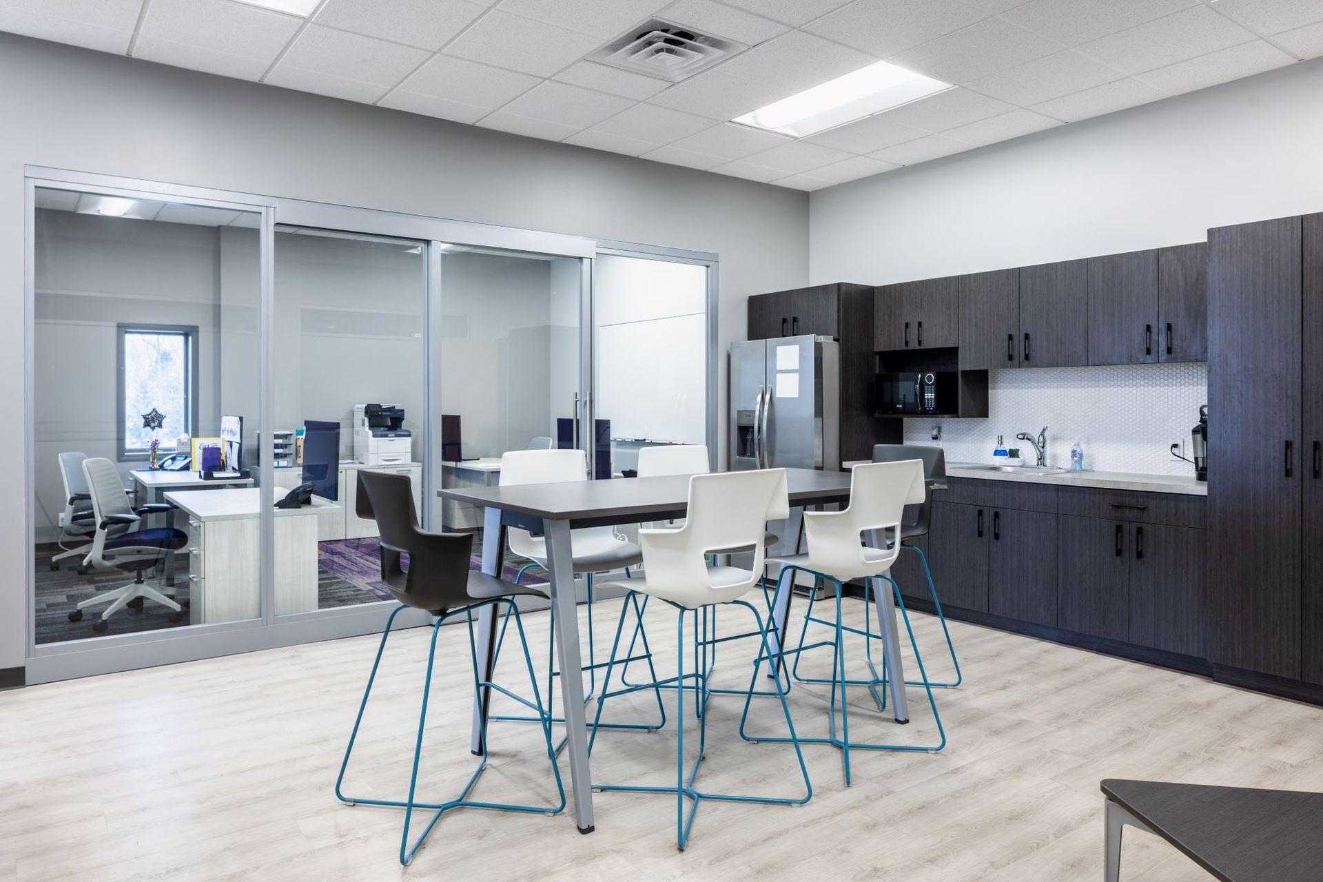 A kitchen with a table and chairs in it and a refrigerator.