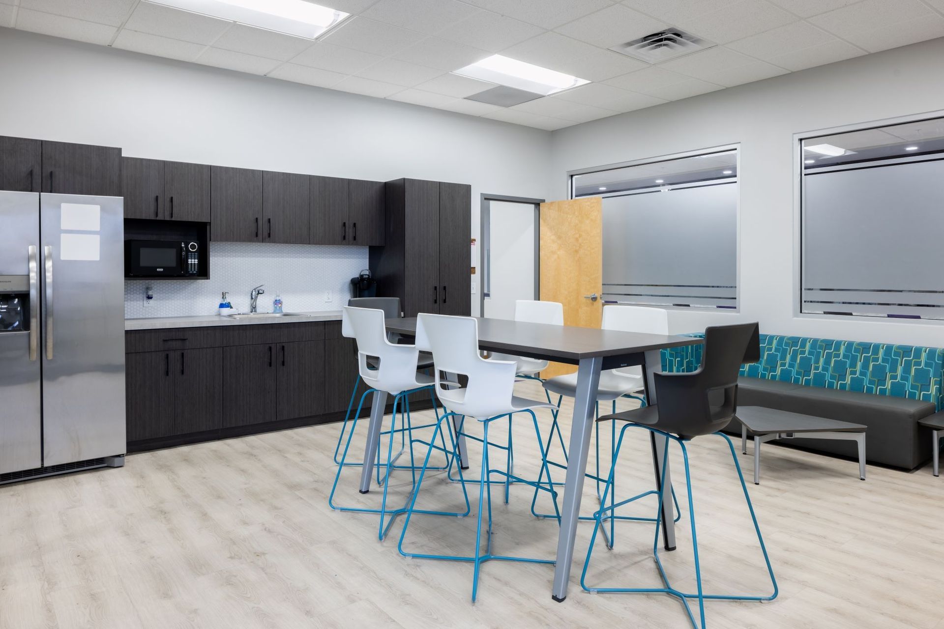 A kitchen with a table and chairs and a refrigerator.