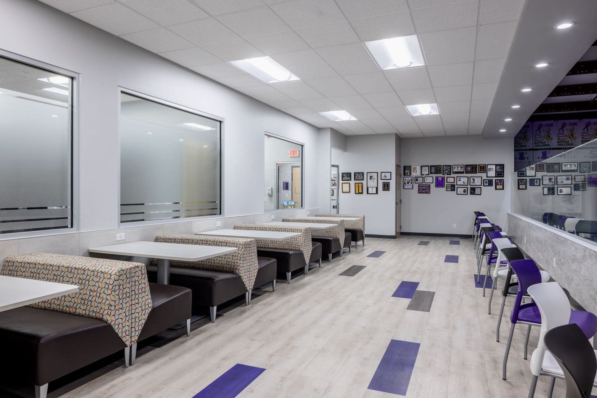 A long hallway with tables and chairs in a restaurant.