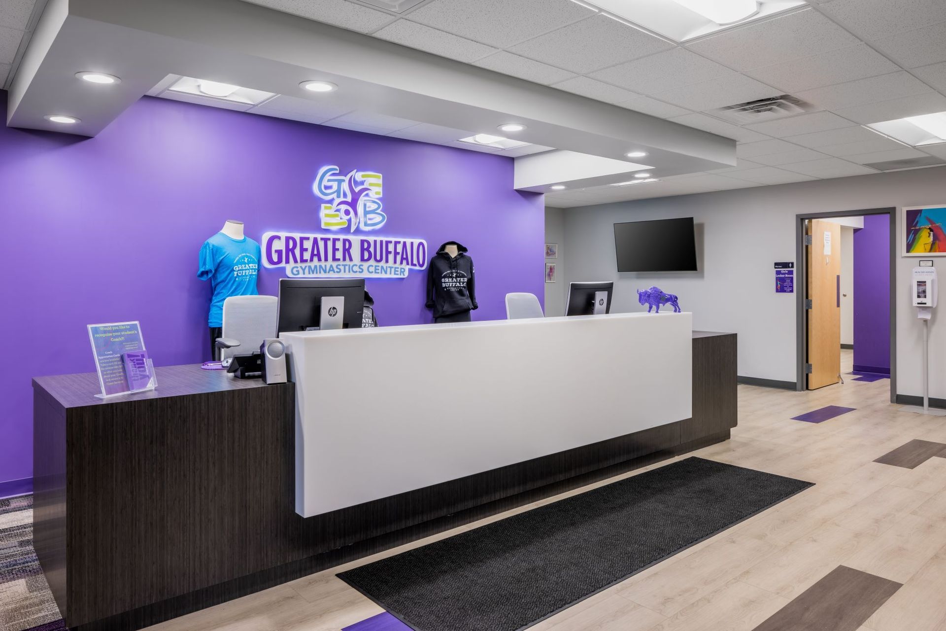 A lobby with a purple wall and a white counter.