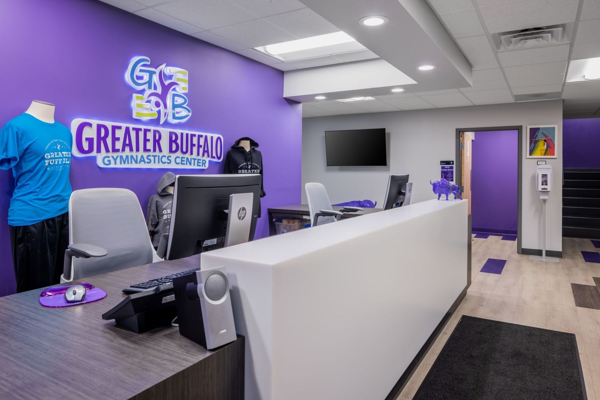 A reception area with a purple wall and a white counter.