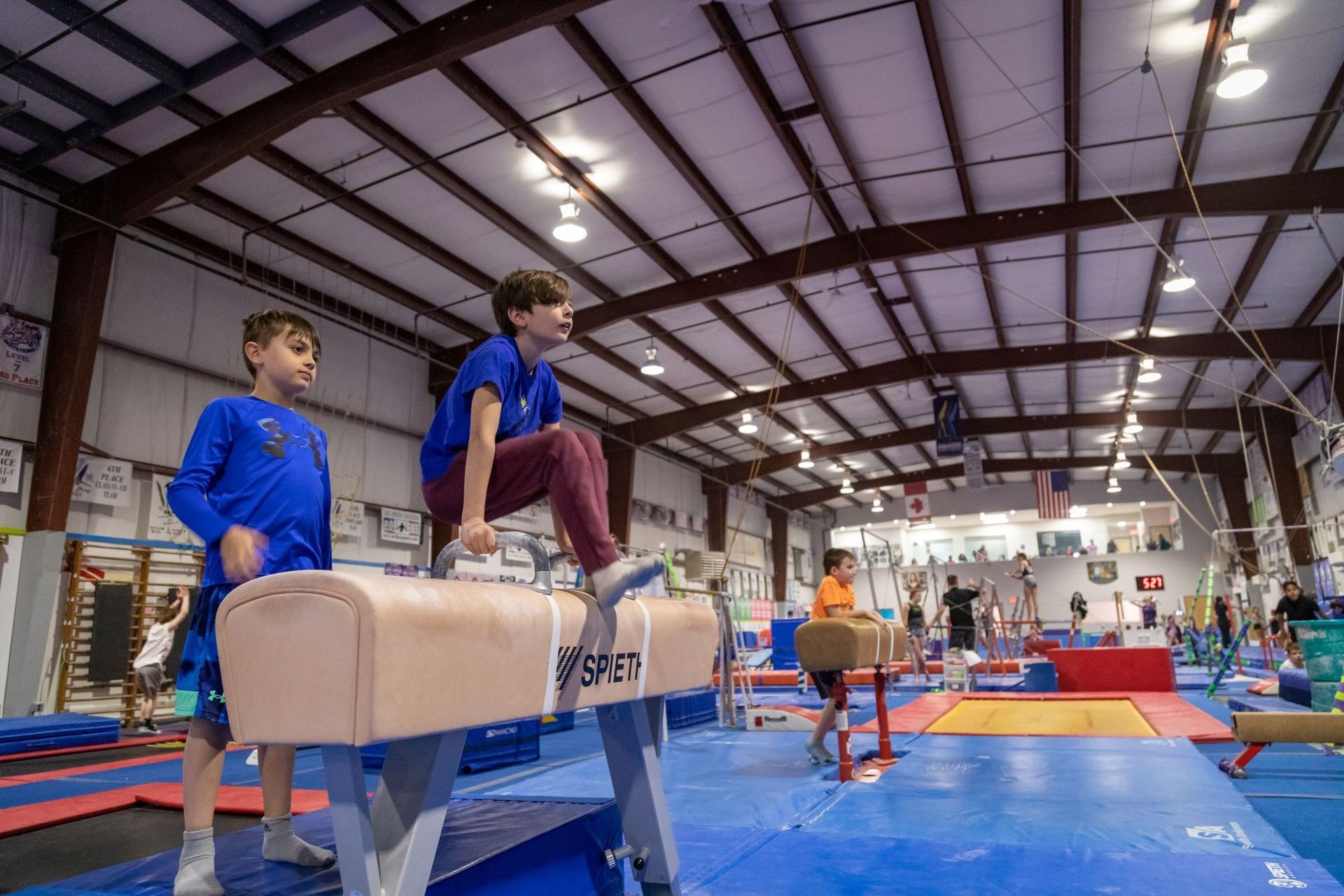 A group of young girls are practicing gymnastics in a gym.