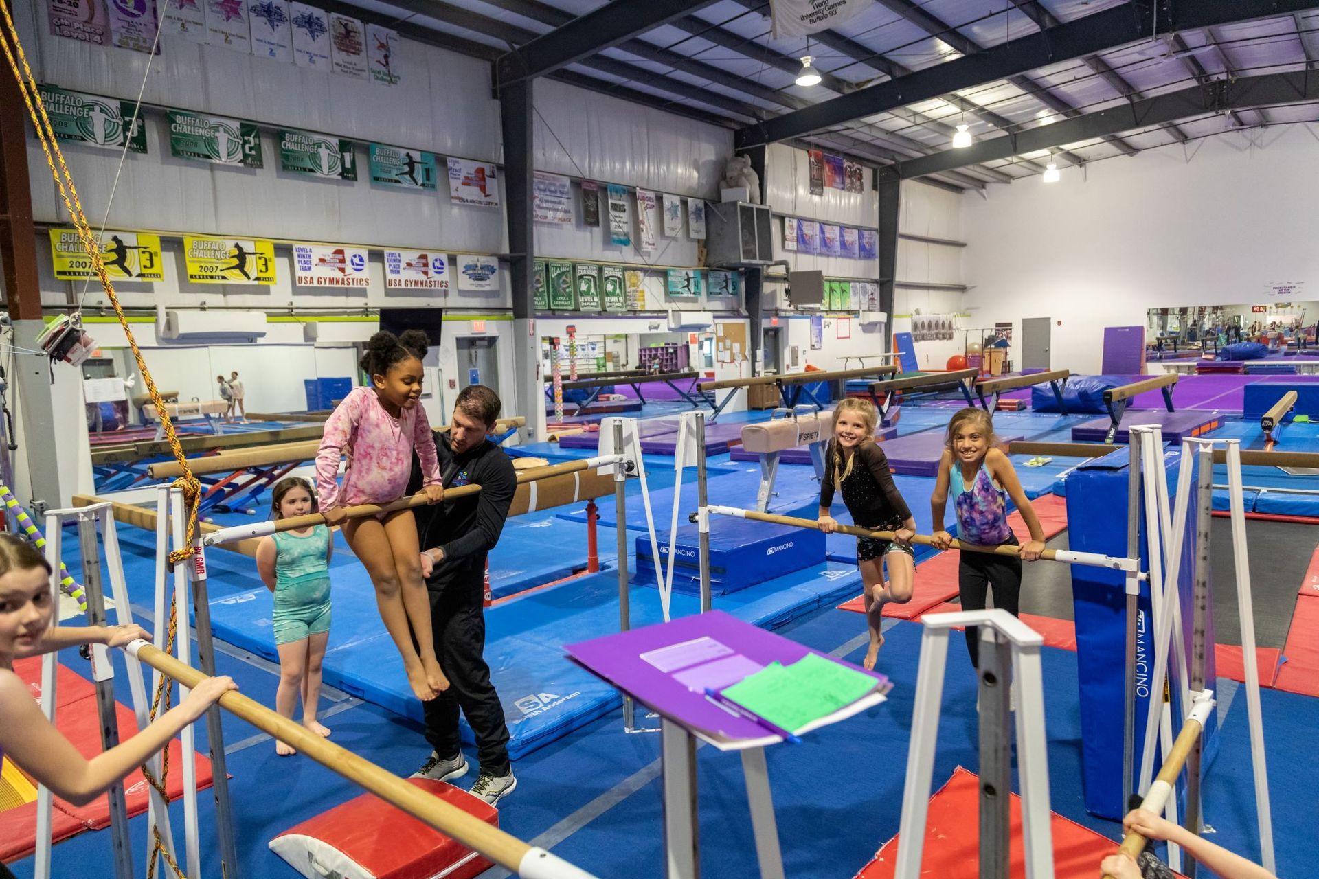 A group of young girls are doing gymnastics in a gym.