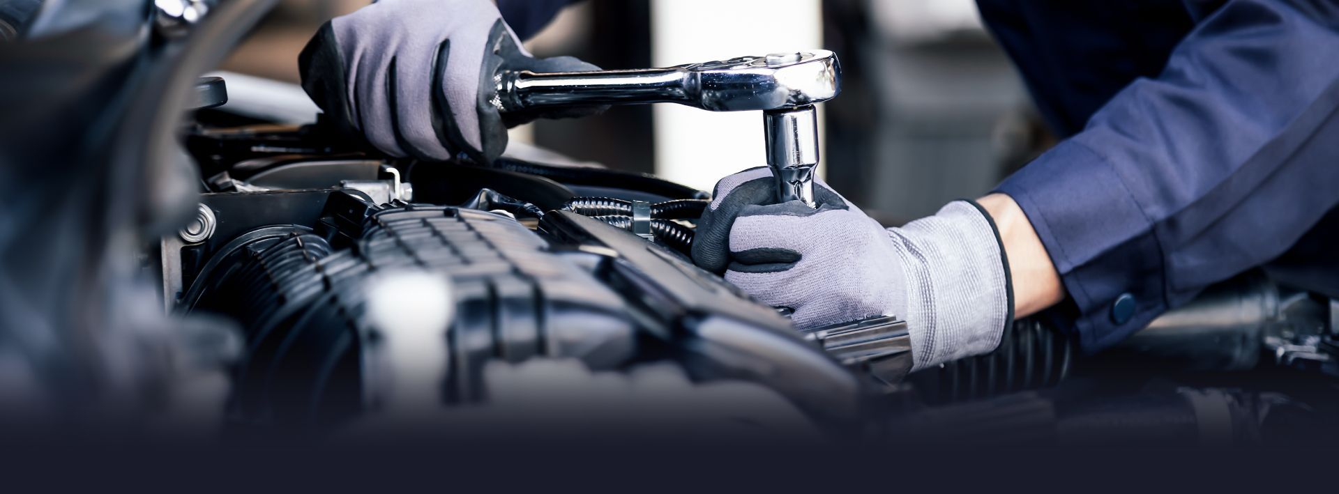 An automotive shop with five cars parked outside. Yellow building with a sign that reads,