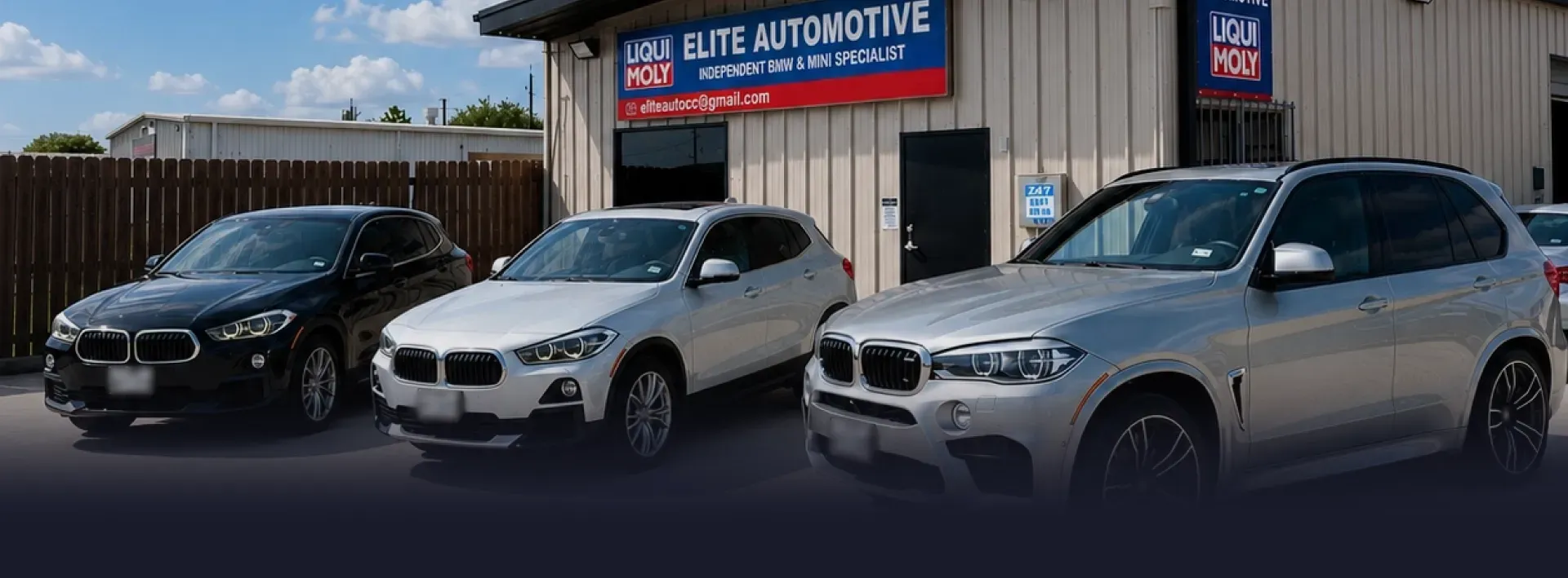 An automotive shop with five cars parked outside. Yellow building with a sign that reads, 