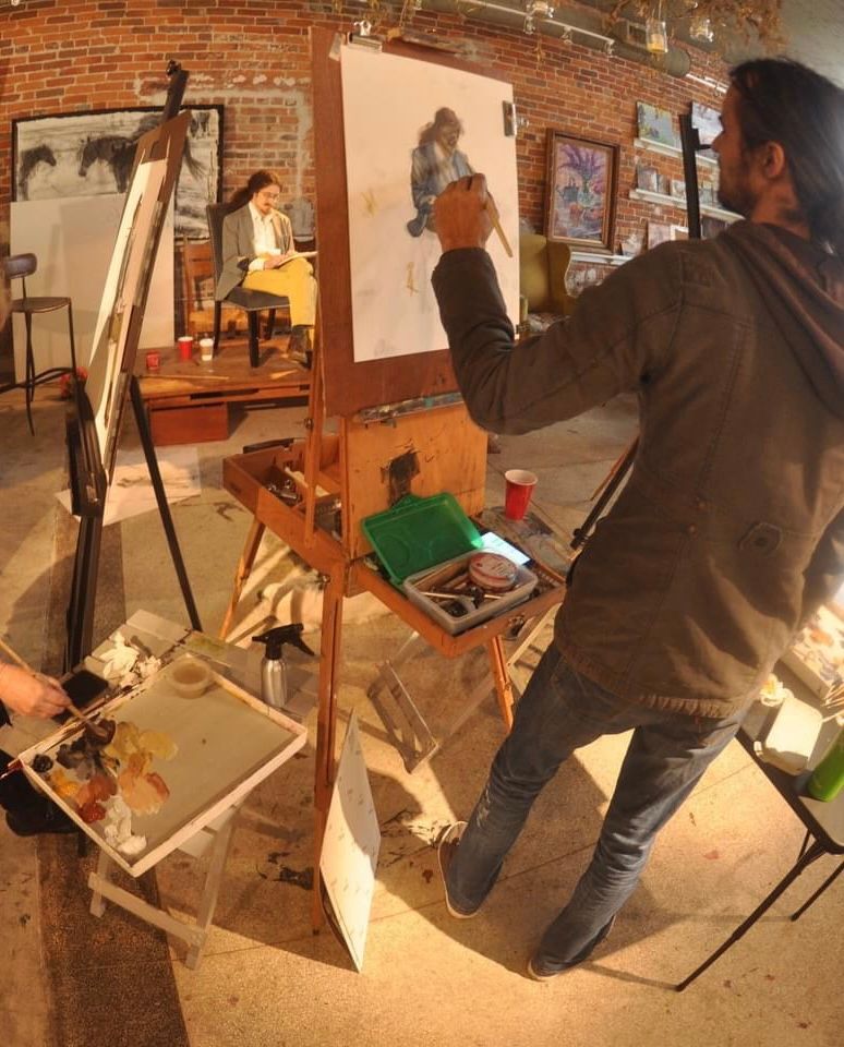 A man is painting a picture on an easel