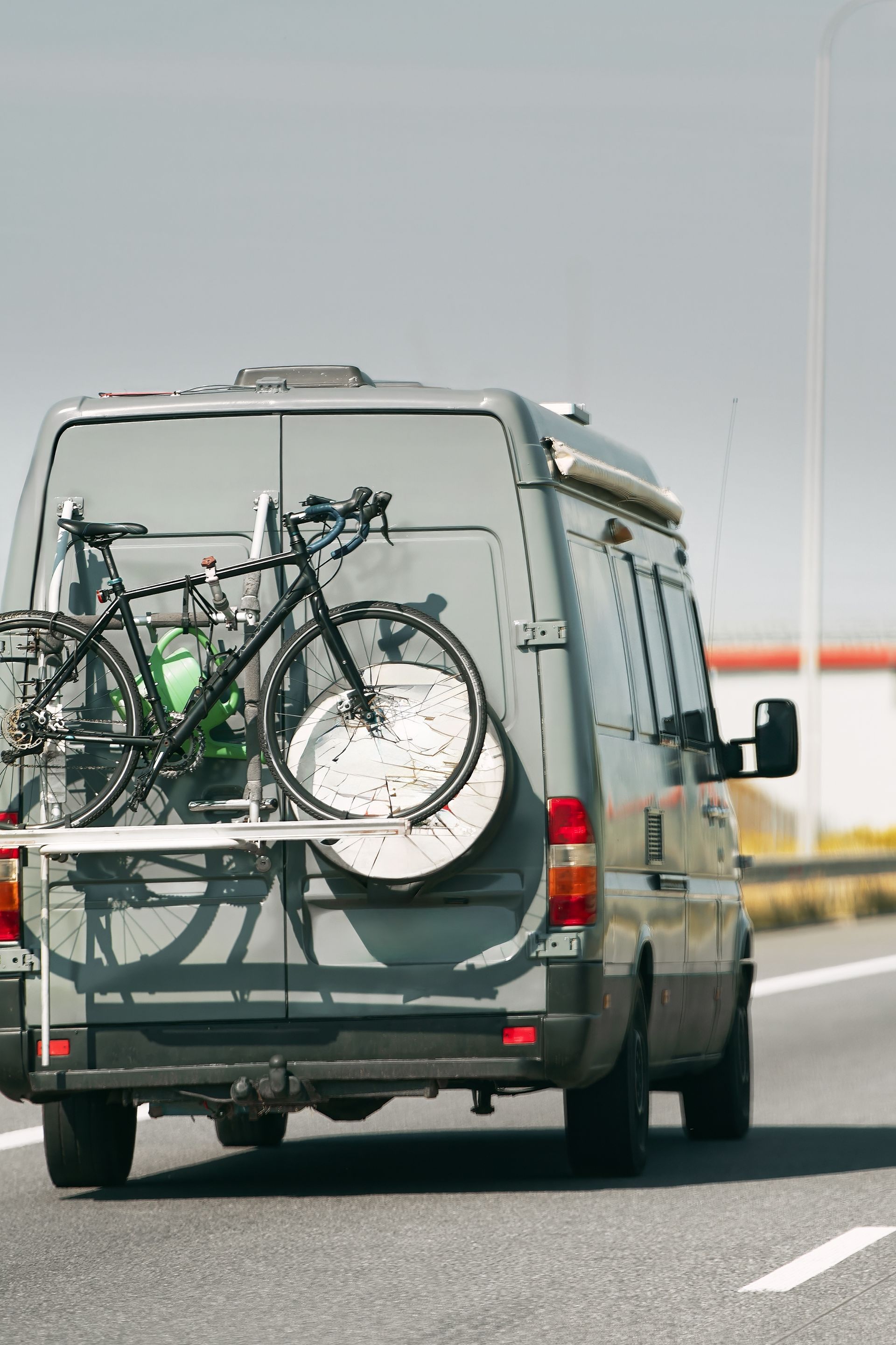 Gray Van Driving on a Highway, Carrying a Bicycle on the Back — Darren's Caravan Repairs in Central Coast, NSW