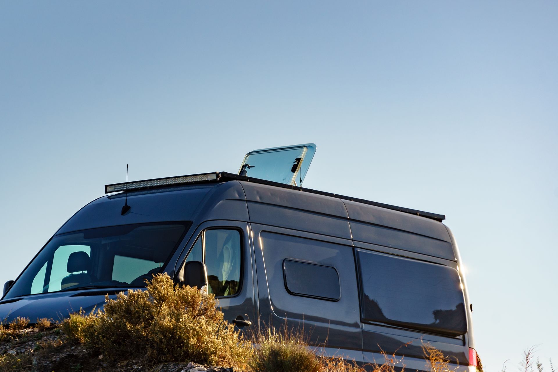 Gray Camper Van With Open Rooftop Window and Blue Sky — Darren's Caravan Repairs in Central Coast, NSW