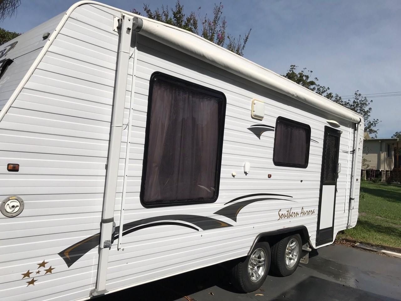 White Travel Trailer With Awning Extended, Parked Outdoors on Pavement — Darren's Caravan Repairs in Warners Bay, NSW