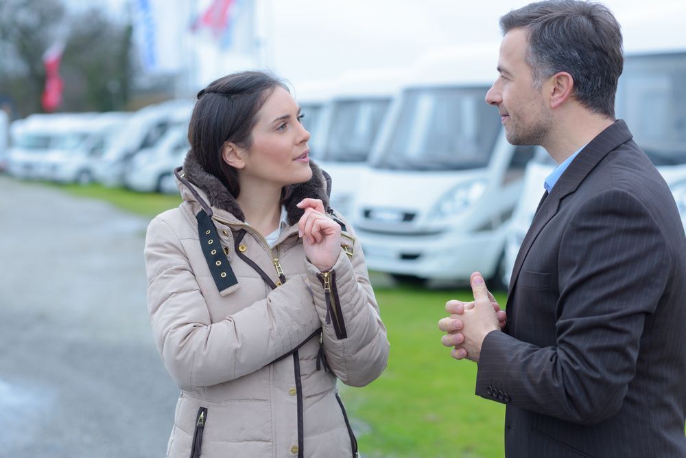 Woman and Man Talking at a RV Caravan Lot — Darren's Caravan Repairs in Warners Bay, NSW