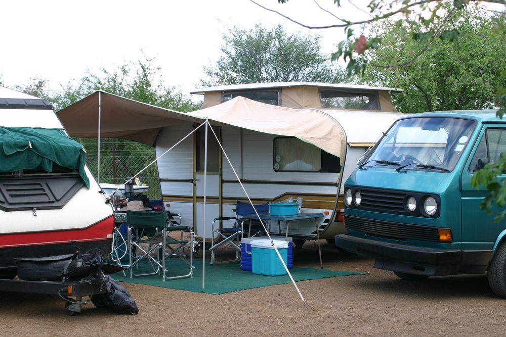 Camping Scene With a Teal Van, Camper, and Tent Awning — Darren's Caravan Repairs in Central Coast, NSW