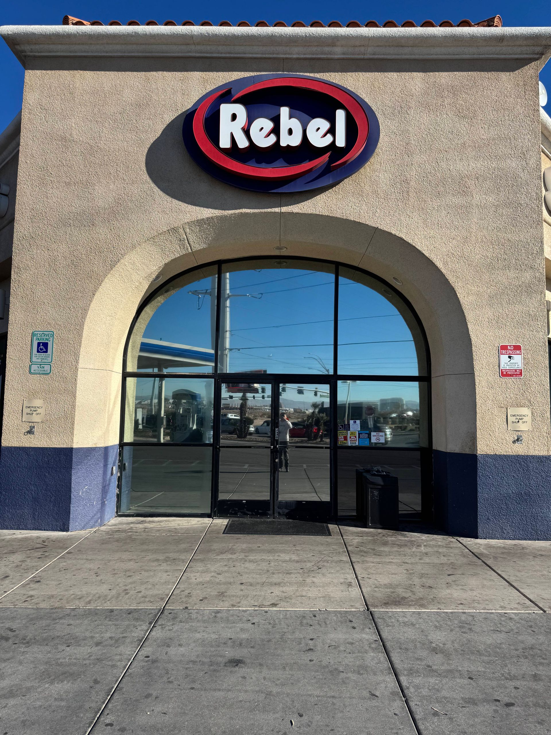 Close-up of car window with tinted glass; white car body visible, with reflection of interior.