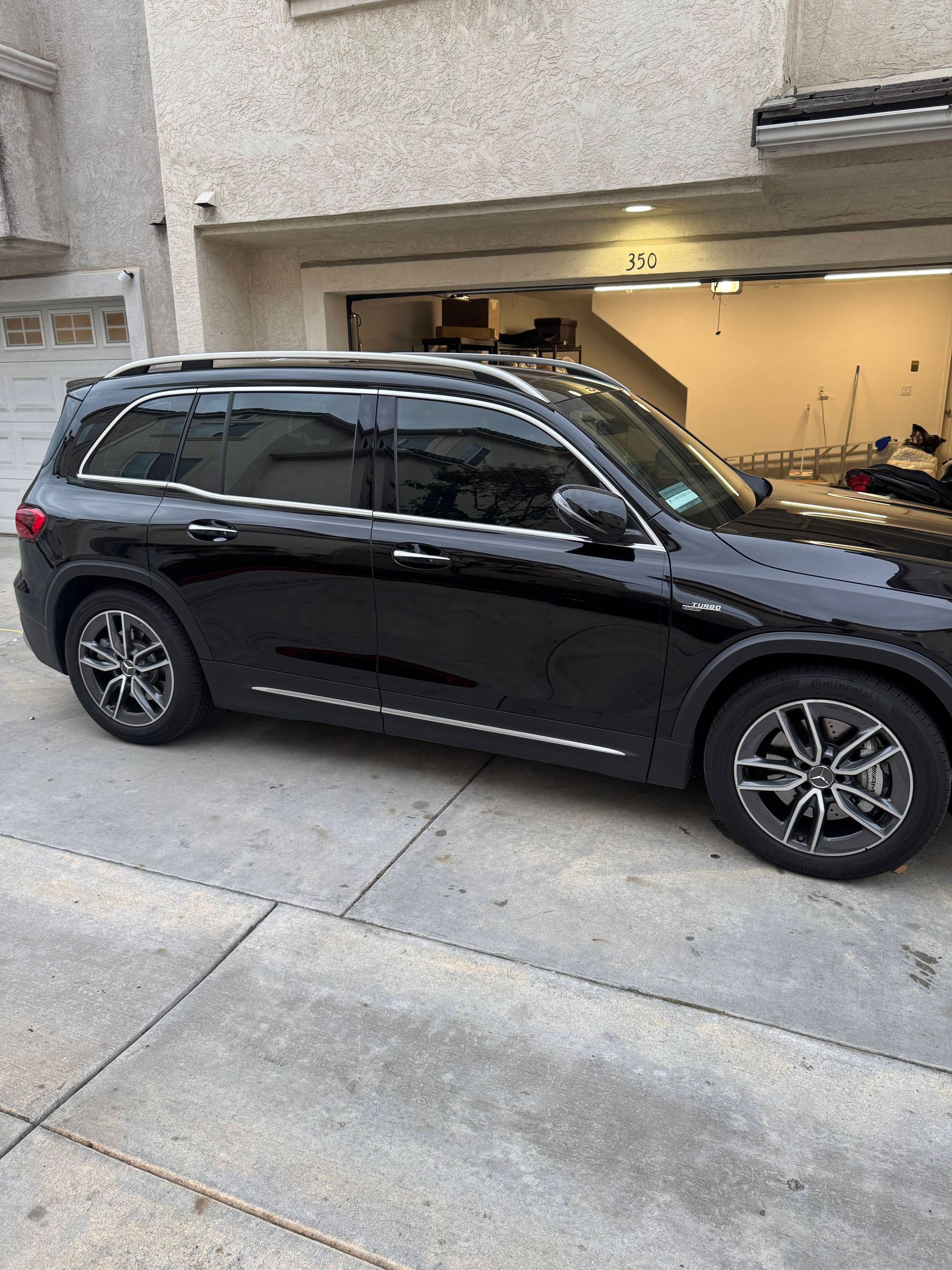 Long hallway with large windows overlooking a city street. Buildings reflect in the glass. Wooden floor.
