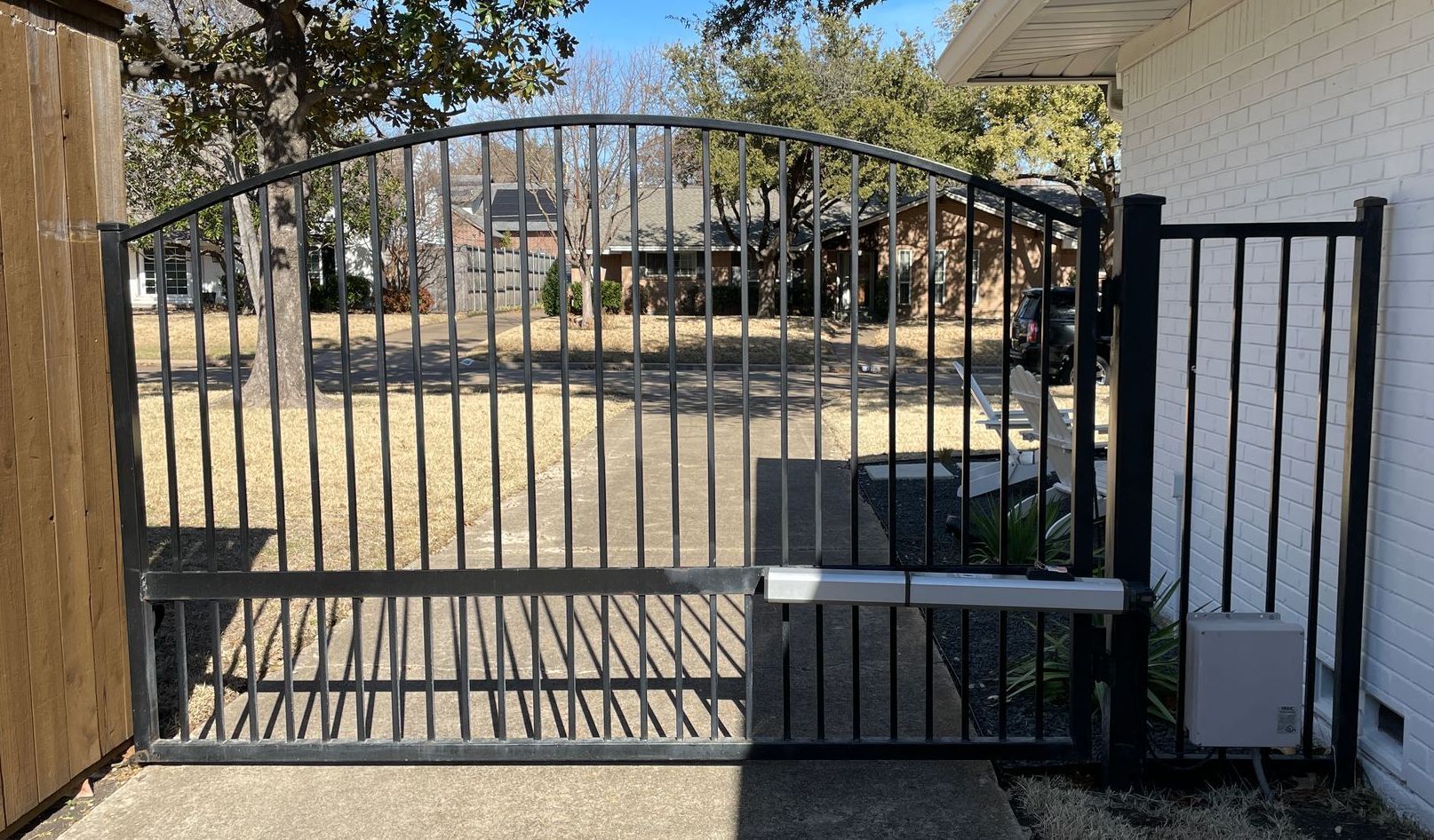 A wrought iron gate is open to a driveway in front of a house. lake havasu