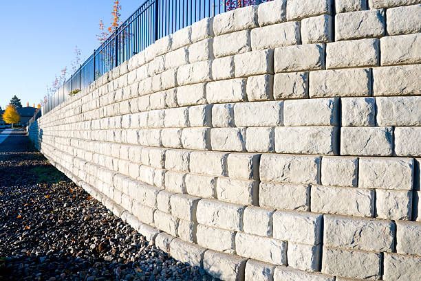 A large white brick wall with a metal fence in the background. Lake havasu