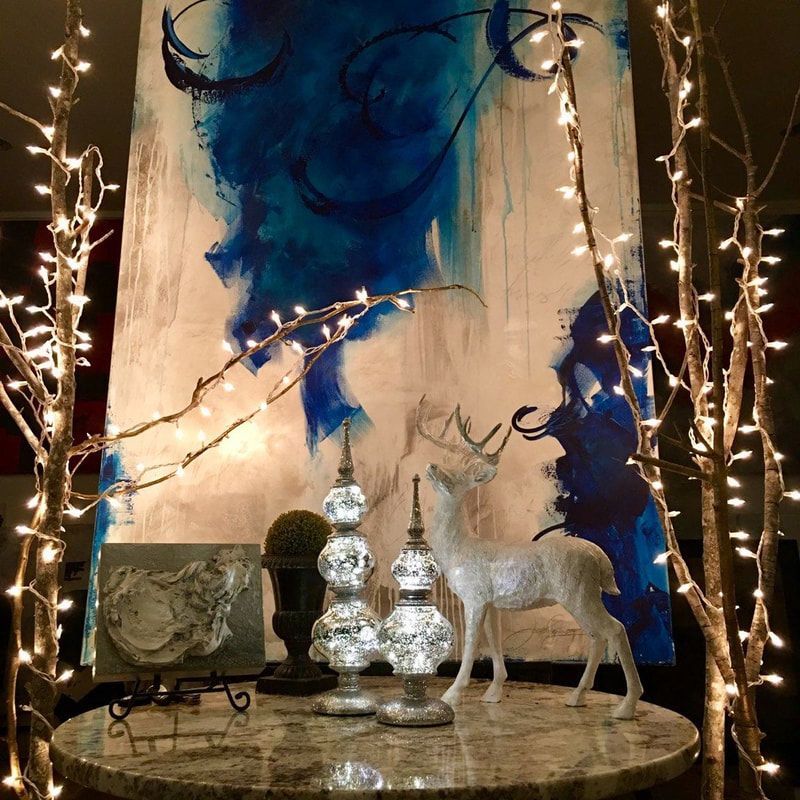 Round table with art, deer statue, and decorative lights.