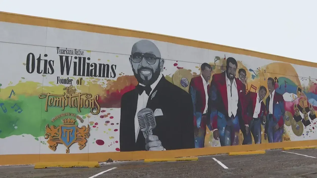 Mural of Otis Williams, founder of The Temptations, with the group members, painted on a wall.