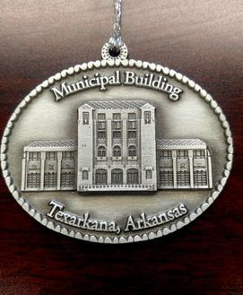 Ornament of Texarkana, Arkansas Municipal Building. Oval, silver-toned, detailed. 