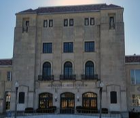 Exterior view of the Manitoba Museum, a large beige stone building with multiple windows under a clear sky.